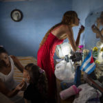 
              Liusba Grajales, left, puts makeup on her daughter Ainhoa as her partner Lisset Diaz Vallejo gets ready as they prepare to get married, one of the first same-sex couples to make the decision to get legally married in Cuba following the new Family Code, in Santa Clara, Cuba, on Oct. 21, 2022. (AP Photo/Ismael Francisco)
            