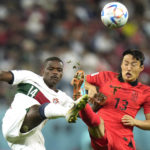 
              Portugal's William Carvalho, left, and South Korea's Son Jun-ho challenge for the ball during the World Cup group H soccer match between South Korea and Portugal, at the Education City Stadium in Al Rayyan , Qatar, Friday, Dec. 2, 2022. (AP Photo/Francisco Seco)
            
