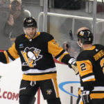 Pittsburgh Penguins' Bryan Rust (17) celebrates with Chad Ruhwedel (2) after scoring against the St. Louis Blues during the first period of an NHL hockey game in Pittsburgh, Saturday, Dec. 3, 2022. (AP Photo/Gene J. Puskar)