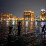 Children play on the water in Katara beach in Doha, Qatar, Thursday, Dec. 8, 2022. (AP Photo/Natacha Pisarenko)