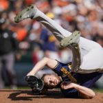 Milwaukee Brewers starting pitcher Adrian Houser rolls on his back after catching a ball hit by Baltimore Orioles' Austin Hays during the fourth inning of a baseball game at Oriole Park at Camden Yards, Monday, April 11, 2022, in Baltimore. (AP Photo/Julio Cortez)
