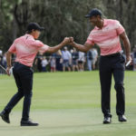
              Tiger Woods, right and his son Charlie Woods bump fists on the ninth green during the first round of the PNC Championship golf tournament Saturday, Dec. 17, 2022, in Orlando, Fla. (AP Photo/Kevin Kolczynski)
            
