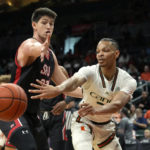 Miami guard Isaiah Wong, right, passes the ball as St. Francis forward Josh Cohen defends during the first half of an NCAA college basketball game, Saturday, Dec. 17, 2022, in Coral Gables, Fla. (AP Photo/Lynne Sladky)