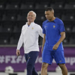 France's head coach Didier Deschamps, left, and Kylian Mbappe arrive for a training session in Doha, Qatar, Friday, Dec. 9, 2022 on the eve of the World Cup quarterfinal soccer match between France and England. (AP Photo/Christophe Ena)