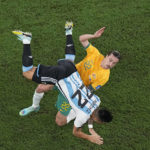 Argentina's Lautaro Martinez falls while battling for the ball with Australia's Jackson Irvine during the World Cup round of 16 soccer match between Argentina and Australia at the Ahmad Bin Ali Stadium in Doha, Qatar, Saturday, Dec. 3, 2022. (AP Photo/Pavel Golovkin)