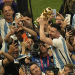 
              Argentina's Lionel Messi holds the winners trophy as he celebrates with fans after Argentina won the World Cup final soccer match against France at the Lusail Stadium in Lusail, Qatar, Sunday, Dec. 18, 2022. (AP Photo/Francisco Seco)
            