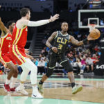 
              Charlotte Hornets guard Terry Rozier, right, passes the ball around the defense of Atlanta Hawks guard Trent Forrest, left, and forward Frank Kaminsky, center, during the first half of an NBA basketball game Friday, Dec. 16, 2022, in Charlotte, N.C. (AP Photo/Rusty Jones)
            