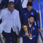 
              Argentina's captain Lionel Messi holds the FIFA World Cup trophy as he deplanes in Buenos Aires, Argentina, early Tuesday, Dec. 20, 2022. (AP Photo/Gustavo Garello)
            