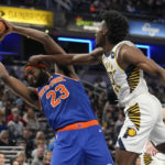 
              Indiana Pacers forward Aaron Nesmith, right, gets his hand on New York Knicks center Mitchell Robinson during the first half of an NBA basketball game in Indianapolis, Sunday, Dec. 18, 2022. (AP Photo/AJ Mast)
            