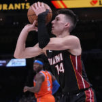 Miami Heat guard Tyler Herro (14) shoots in front of Oklahoma City Thunder forward Luguentz Dort (5) in the first half of an NBA basketball game Wednesday, Dec. 14, 2022, in Oklahoma City. (AP Photo/Sue Ogrocki)