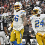 
              Los Angeles Chargers defensive end Morgan Fox (56) and safety Nasir Adderley (24) reacts after a fumble recovery and Las Vegas Raiders wide receiver Keelan Cole (84) looks on during the first half of an NFL football game, Sunday, Dec. 4, 2022, in Las Vegas. (AP Photo/David Becker)
            