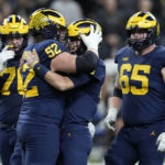 Michigan quarterback J.J. McCarthy is congratulated by teammates Kechaun Bennett (52), Ryan Hayes, left, and Zak Zinter (65) after throwing a touchdown pass during the second half of the Big Ten championship NCAA college football game against Purdue, Saturday, Dec. 3, 2022, in Indianapolis. (AP Photo/Darron Cummings)