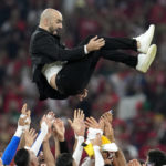 Morocco's head coach Walid Regragui is thrown in the air by his players after winning the World Cup group F soccer match between Canada and Morocco at the Al Thumama Stadium in Doha , Qatar, Thursday, Dec. 1, 2022. (AP Photo/Natacha Pisarenko)