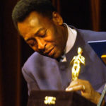 
              FILE - Brazilian soccer legend Pelé looks at a statue given by the Rio de Janeiro Gov. Rosinha Matheus, at the Municipal Theater in Rio de Janeiro, Monday, June 21, 2004. The recognition was given during the premier of the movie "Pelé Eterno." Pelé, who won a record three World Cups and became one of the most commanding sports figures of the last century, died in Sao Paulo on Thursday, Dec. 29, 2022. He was 82. (AP Photo/Victor R. Caivano, File)
            