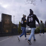
              Pittsburgh Steelers fans walk past a marker commemorating the exact spot where the 1972 "Immaculate Reception," was made by Franco Harris at Three Rivers Stadium, which once stood on the North Side of Pittsburgh, on Sunday, Dec. 11, 2022, in Pittsburgh, Pa. Harris' scoop of a deflected pass and subsequent run for the winning touchdown in a 1972 playoff victory against Oakland has been voted the greatest play in NFL history and celebrates its 50th anniversary this year. (AP Photo/Jessie Wardarski)
            
