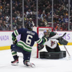 Vancouver Canucks' Brock Boeser (6) scores against Arizona Coyotes goalie Karel Vejmelka during the third period of an NHL hockey game Saturday, Dec. 3, 2022, in Vancouver, British Columbia. (Darryl Dyck/The Canadian Press via AP)