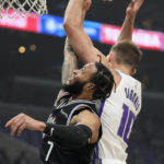 Sacramento Kings forward Domantas Sabonis, right, grabs a rebound away from Los Angeles Clippers guard Amir Coffey during the first half of an NBA basketball game Saturday, Dec. 3, 2022, in Los Angeles. (AP Photo/Mark J. Terrill)