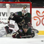 Arizona Coyotes defenseman Shayne Gostisbehere (14) helps block a shot by the Colorado Avalanche in front of Coyotes goaltender Connor Ingram (39) during the third period of an NHL hockey game in Tempe, Ariz., Tuesday, Dec. 27, 2022. The Coyotes won 6-3. (AP Photo/Ross D. Franklin)