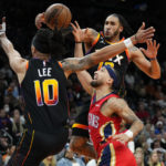 New Orleans Pelicans guard Jose Alvarado, center, has his shot blocked by Phoenix Suns forward Ish Wainright as guard Damion Lee (10) defends during the first half of an NBA basketball game, Saturday, Dec. 17, 2022, in Phoenix. (AP Photo/Matt York)
