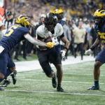 Purdue wide receiver Tyrone Tracy (3) runs with the ball as Michigan defensive back DJ Turner (5) and linebacker Junior Colson (25) defend during the first half of the Big Ten championship NCAA college football game, Saturday, Dec. 3, 2022, in Indianapolis. (AP Photo/Michael Conroy)