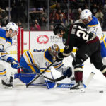 Arizona Coyotes' Barrett Hayton (29) loses the puck as he is outnumbered by Buffalo Sabres' Jeremy Davis (4), goalie Craig Anderson (41) and Victor Olofsson (71) in the first period during an NHL hockey game, Saturday, Dec. 17, 2022, in Tempe, Ariz. (AP Photo/Darryl Webb)