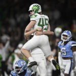 
              Oregon place-kicker Camden Lewis (49) is lifted by Adam Barry (93) after Lewis kicked an extra point against North Carolina during the second half of the Holiday Bowl NCAA college football game Wednesday, Dec. 28, 2022, in San Diego. (AP Photo/Denis Poroy)
            