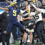 Purdue wide receiver Charlie Jones (15) catches a pass for a 32-yard gain as Michigan defensive back DJ Turner (5) defends during the second half of the Big Ten championship NCAA college football game, Saturday, Dec. 3, 2022, in Indianapolis. (AP Photo/AJ Mast)