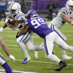 Indianapolis Colts running back Deon Jackson (35) tries to break a tackle by Minnesota Vikings linebacker Danielle Hunter (99) during the first half of an NFL football game, Saturday, Dec. 17, 2022, in Minneapolis. (AP Photo/Andy Clayton-King)