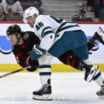 
              Ottawa Senators right wing Alex DeBrincat (12) gets becomes entangled with San Jose Sharks center Tomas Hertl (48) during the second period of an NHL hockey game Saturday, Dec. 3, 2022, in Ottawa, Ontario. (Justin Tang/The Canadian Press via AP)
            