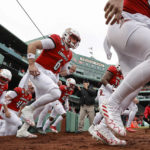 Louisville takes the field before the Fenway Bowl NCAA college football game against Cincinnati at Fenway Park, Saturday, Dec. 17, 2022, in Boston. (AP Photo/Winslow Townson)