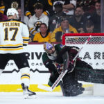 Arizona Coyotes goaltender Karel Vejmelka, right, makes a save on a shot by Boston Bruins left wing Nick Foligno (17) during the third period of an NHL hockey game in Tempe, Ariz., Friday, Dec. 9, 2022. The Coyotes won 4-3. (AP Photo/Ross D. Franklin)