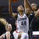 Connecticut's Aubrey Griffin (44) goes up for a basket as Providence's Olivia Olsen, right, defends in the first half of an NCAA college basketball game, Friday, Dec. 2, 2022, in Storrs, Conn. (AP Photo/Jessica Hill)