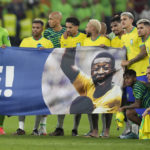 
              Brazil's players shows a banner in support of Brazilian soccer legend Pele at the end of the World Cup round of 16 soccer match between Brazil and South Korea, at the Stadium 974 in Doha, Qatar, Monday, Dec. 5, 2022. (AP Photo/Andre Penner)
            