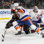 New York Islanders defenseman Noah Dobson (8) checks Arizona Coyotes left wing Nick Ritchie (12) off the puck in the first period during an NHL hockey game, Friday, Dec. 16, 2022, in Tempe, Ariz. (AP Photo/Rick Scuteri)