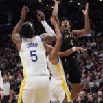 Toronto Raptors forward Scottie Barnes (4) goes for a layup as Golden State Warriors center Kevon Looney (5) and Jordan Poole (3) defend during first-half NBA basketball game action in Toronto, Sunday, Dec. 18, 2022. (Frank Gunn/The Canadian Press via AP)