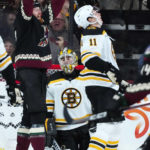 Arizona Coyotes left wing Lawson Crouse, left, celebrates his goal against Boston Bruins goaltender Jeremy Swayman, middle, as Bruins center Trent Frederic (11) reacts to the score during the second period of an NHL hockey game in Tempe, Ariz., Friday, Dec. 9, 2022. (AP Photo/Ross D. Franklin)