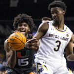 Miami's Norchad Omier (15) and Notre Dame's Trey Wertz (3) fight for a loose ball during the first half of an NCAA college basketball game Friday, Dec. 30, 2022 in South Bend, Ind. (AP Photo/Michael Caterina)