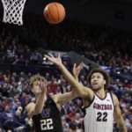 Washington guard Cole Bajema, left, and Gonzaga forward Anton Watson, right, go after the ball during the first half of an NCAA college basketball game, Friday, Dec. 9, 2022, in Spokane, Wash. (AP Photo/Young Kwak)