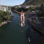 
              A diver jumps from the Old Bridge during the 456th traditional annual high diving competition in Mostar, Bosnia, Sunday, July 31, 2022. A total of 31 divers from Bosnia and region leapt from the 23-meter-high bridge into the Neretva River. (AP Photo/Armin Durgut)
            