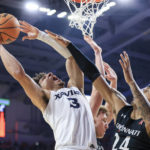 Xavier's guard Colby Jones (3) drives to the basket as he is fouled by Cincinnati's guard Jeremiah Davenport (24) during the second half of an NCAA college basketball game, Saturday, Dec. 10, 2022, in Cincinnati. Xavier won 80-77. (AP Photo/Aaron Doster)