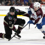 Arizona Coyotes center Nick Bjugstad (17) battles with Colorado Avalanche center Ben Meyers for the puck during the second period of an NHL hockey game in Tempe, Ariz., Tuesday, Dec. 27, 2022. (AP Photo/Ross D. Franklin)