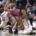 Florida State's Jazmine Massengill and Connecticut's Nika Muhl, right, fight for the ball as Connecticut's Aubrey Griffin, left, defends during the first half of an NCAA college basketball game, Sunday, Dec. 18, 2022, in Uncasville, Conn. (AP Photo/Jessica Hill)