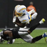 Los Angeles Chargers tight end Tre' McKitty (88) is tackled by Las Vegas Raiders cornerback Nate Hobbs (39) during the first half of an NFL football game, Sunday, Dec. 4, 2022, in Las Vegas. (AP Photo/David Becker)