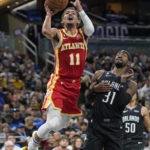 
              Atlanta Hawks' Trae Young (11) is fouled by Orlando Magic's Terrence Ross (31) as he attempts a shot during the first half of an NBA basketball game, Wednesday, Dec. 14, 2022, in Orlando, Fla. (AP Photo/John Raoux)
            