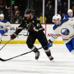 Arizona Coyotes' Lawson Crouse (67) chases the puck before Buffalo Sabres' Jeremy Davis (4) in the first period during an NHL hockey game, Saturday, Dec. 17, 2022, in Tempe, Ariz. (AP Photo/Darryl Webb)