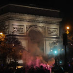 Supporters of France celebrate with flares next to the Arc de Triomphe and the Champs Elysees avenue at the end of the World Cup semifinal soccer match between France and Morocco, in Paris, Wednesday, Dec. 14, 2022. (AP Photo/Thibault Camus)