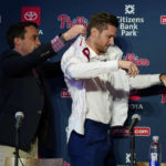 
              Philadelphia Phillies general manager Sam Fuld, left, helps newly acquired shortstop Trea Turner with his jersey during his introductory news conference, Thursday, Dec. 8, 2022, in Philadelphia. (AP Photo/Matt Slocum)
            