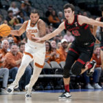 
              Texas forward Timmy Allen (0) drives past Stanford forward Maxime Raynaud (42) on a fast break during the first half of an NCAA college basketball game, Sunday, Dec. 18, 2022, in Dallas. (AP Photo/Jeffrey McWhorter)
            