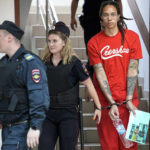 FILE - WNBA star and two-time Olympic gold medalist Brittney Griner is escorted to a courtroom for a hearing in Khimki just outside Moscow, on July 7, 2022. She pleaded guilty over the summer, admitting that she had the canisters in her luggage but that she packed them inadvertently in her haste to make her flight and had no criminal intent. (AP Photo/Alexander Zemlianichenko, File)