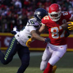 Kansas City Chiefs tight end Travis Kelce (87) catches a pass as Seattle Seahawks safety Teez Tabor (39) defends during the first half of an NFL football game Saturday, Dec. 24, 2022, in Kansas City, Mo. (AP Photo/Ed Zurga)